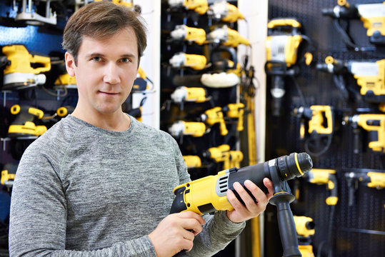 Man with hammer drill in hardware store