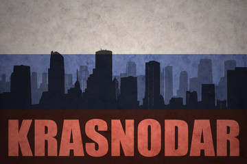 Fototapeta premium abstract silhouette of the city with text Krasnodar at the vintage russian flag