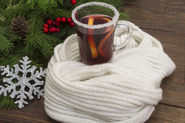 mulled wine in female hands with orange and Christmas ornaments