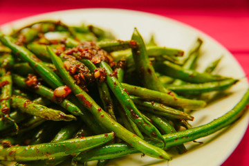 Fresh Organic Cooked Green Beans in a bowl on the red nupkin