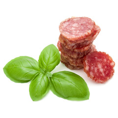 Salami smoked sausage slices and basil leaves isolated on white