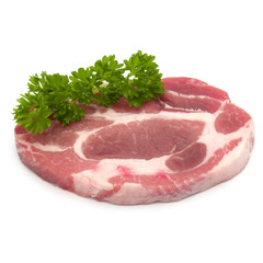 Raw pork neck chop meat with parsley herb leaves garnish isolate