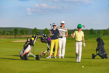 Boy golfer with parents plaing golf at sunny day