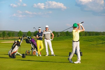 Boy golfer with parents plaing golf at sunny day