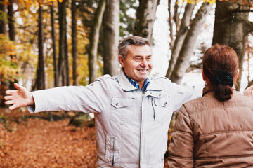 Senior couple enjoying autumn in forest.