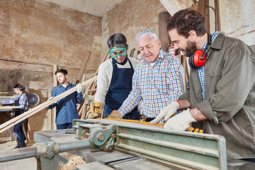 Schreiner und Lehrling an Hobelmaschine