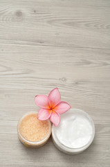 Obraz na płótnie Canvas Body lotion and bath salt displayed with a frangipani flower