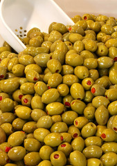 green olives for sale with spicy filling in the italian stall