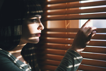 The girl looks into the slit shutters