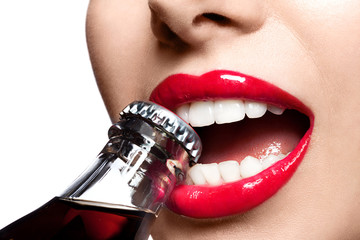 Closeup of beautiful female lips red with white teeth, opening the cork of the bottle with soda