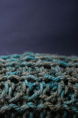 Large binding needles. Wool knitted fabric. Wool textiles. Crochet. Scarf. Background.