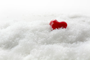 Small red heart in the white snow, generous copy space, love concept for christmas and valentine's day