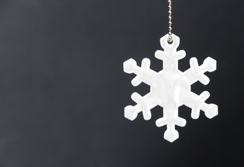 Cute white safety reflector in the form of snowflakes on black background. Necessary equipment to pedestrians for walks during dark conditions.