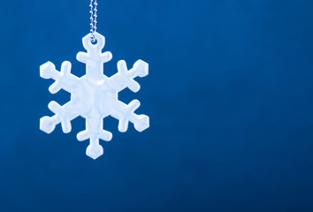 Cute white safety reflector in the form of snowflakes on blue background. Necessary equipment to...