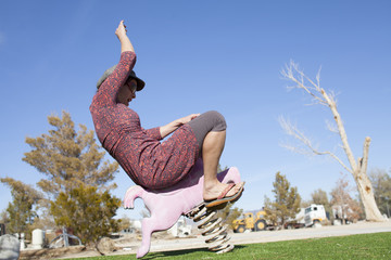 An adult woman playing cowgirl with a stylish playground performance near Lone Pine, California.