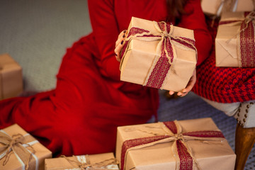 Woman with Christmas gifts in home interior, close up