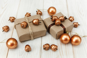 Christmas composition.Present boxes with twine and craft paper,golden acorns and balls.White wooden...