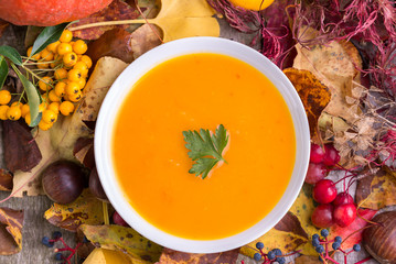 Autumn pumpkin soup with colorful background.