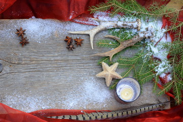 Weihnachtsdeko für Jäger, altes Brett mit Tannengrün, Fasanfedern, Rehbockstangen, Sternanis und Glitzerstern