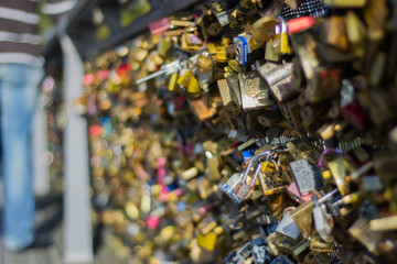Padlocks on a fence. In Paris, lovers are attaching padlocks with their names to many bridges.