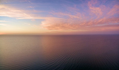 Aerial panoramic view of sunset over ocean. Nothing but sky, clouds and water. Beautiful serene scene