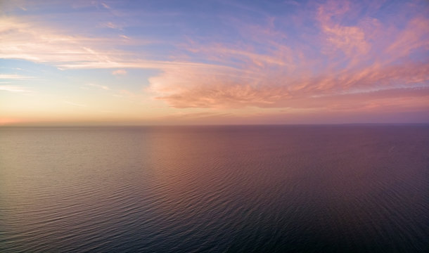 Aerial panoramic view of sunset over ocean. Nothing but sky, clouds and water. Beautiful serene scene © Greg Brave