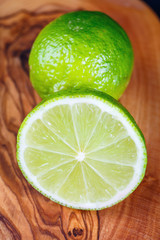 close up of green lemon on wooden background