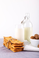 Fototapeta na wymiar fresh healthy milk, cookies with raisins, walnuts on white background. selective focus.