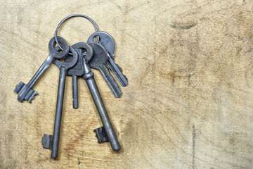 A bunch of old keys on the wooden plate