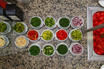 Salad bar with various sliced fresh vegetables