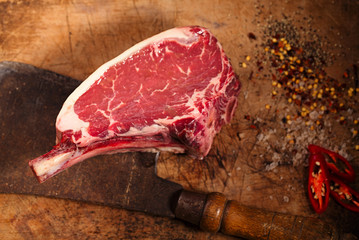 raw beef meat steak on wooden table with meat cleaver