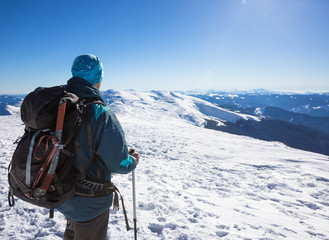 Young happy traveler hiking in beautiful mountains. Fantastic winter landscape