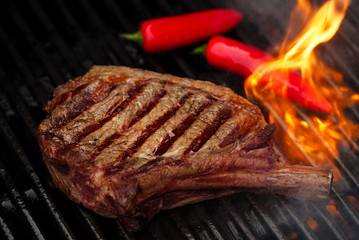 food meat - beef steak on bbq barbecue grill with flame