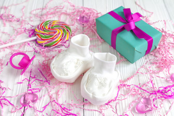 baby's bootees and gift box on wooden background