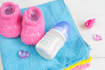 baby bottle with milk and towel on wooden background