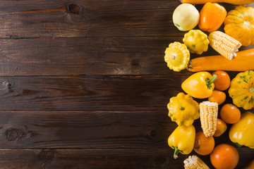 Yellow fruits and vegetables on a    wooden background.  Colorful festive still life. Copyspace. Yellow squash, melon, lemon, banana, pepper, apples, corn