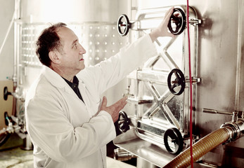 Elderly man in uniform works with equipment