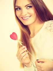 Beautiful woman holding heart shaped hand stick
