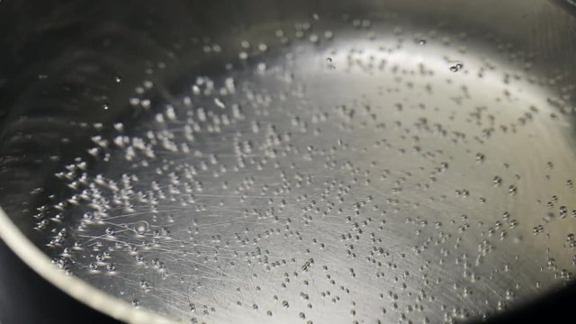 Clean boiling water in a pan close-up