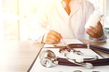 Close-up of stethoscope and folder on background of doctors at work
