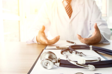 Close-up of stethoscope and folder on background of doctors at work