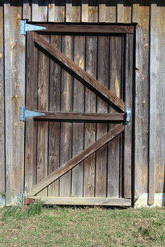 Weathered wood door to a barn stall

