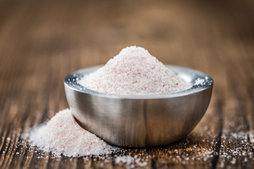 Portion of Himalayan Salt on wooden background (selective focus)