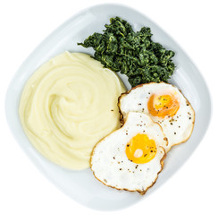 Mashed Potatoes with fried eggs and spinach isolated on white