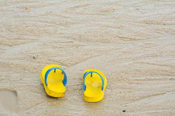 Yellow sandals on sandy beach