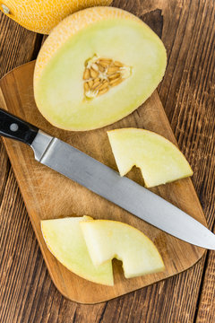 Portion of Honeydew Melon on wooden background (selective focus)