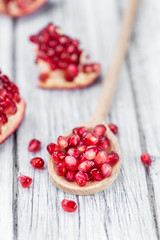 Pomegranate seeds on wooden background (selective focus)