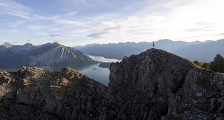 Young man looks out from the peak of a mountain