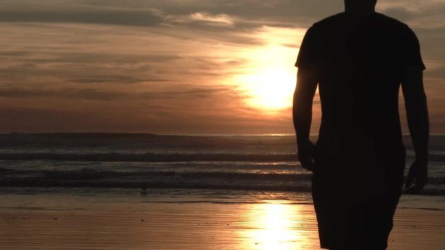 Model released man walks out at sunset on Oregon Coast and enjoys a refreshing evening all by himself.