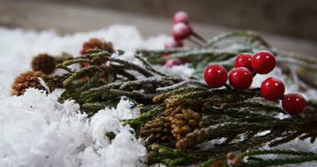Pine cone and red cherries with fake snow